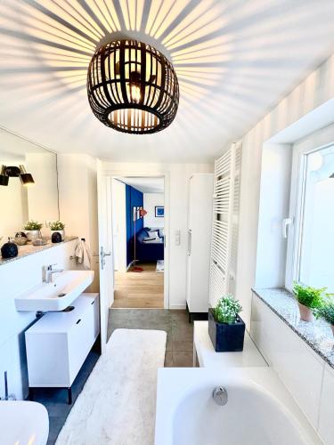 a bathroom with two sinks and a large chandelier at Lake view, central, terrace in Niederdorla