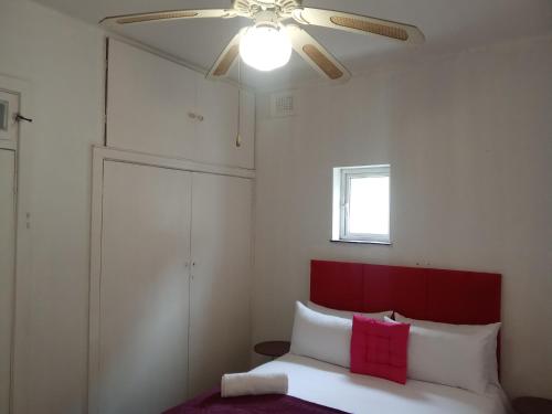 a bedroom with a ceiling fan and a bed at Tranquility Homes in Durban