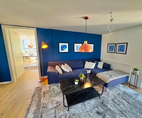 a blue living room with a couch and a table at Lake view, central, terrace in Niederdorla