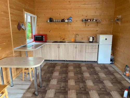 a kitchen with a counter and a refrigerator and a table at Панорама Шаян in Shaian
