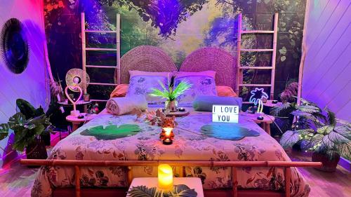 a bedroom with a pink bed with a sign on it at Un Mirage Tropical - Bulles , Spa & Détente en Bord de Loire in Saint-Clément-des-Levées