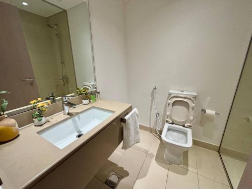 une salle de bain avec un lavabo, des toilettes et un miroir dans l'établissement Relaxing Studio Canal & Pool View Yas Island, à Abu Dhabi