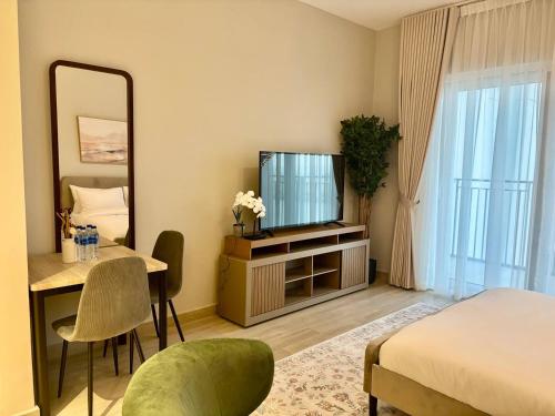 Cette chambre comprend un lit, une table et un miroir. dans l'établissement Relaxing Studio Canal & Pool View Yas Island, à Abu Dhabi