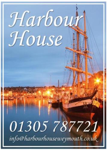 a boat is docked in a harbor at night at Harbour House in Weymouth