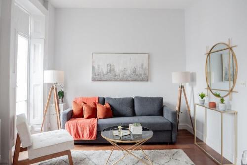 a living room with a blue couch and orange pillows at Stylish Flat in the heart of South Kensington in London