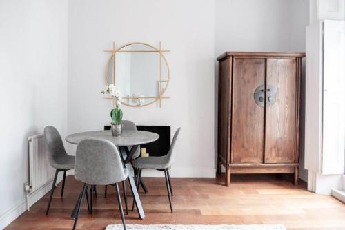 a dining room with a table and chairs and a cabinet at Stylish Flat in the heart of South Kensington in London