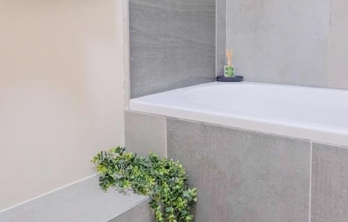 a bathroom with a white tub and a plant at Nat's Villa in Midrand