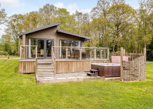 a small house with a hot tub in a field at Ladera Retreat Lodges in Eaton