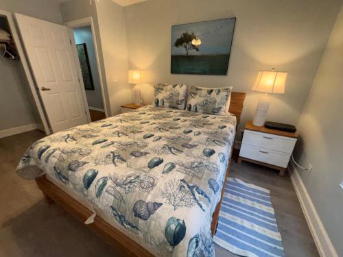 a bedroom with a bed with a blue and white comforter at Tarpon - Spacious Updated W&D Full Kitchen 1.5 Mi to Beach in Bonita Springs