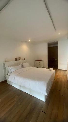 a white bed in a bedroom with a wooden floor at Luxury Stay Rabat Serenity in Rabat