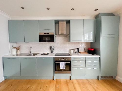 a kitchen with blue cabinets and a sink at Charming one bedroom flat on Portobello Road in London