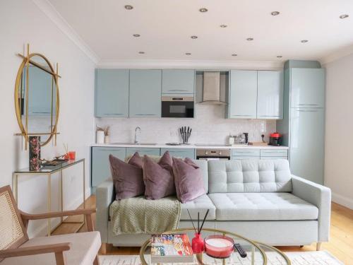 a living room with a couch and a kitchen at Charming one bedroom flat on Portobello Road in London
