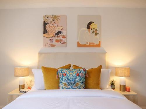 a bedroom with a white bed with two lamps at Charming one bedroom flat on Portobello Road in London