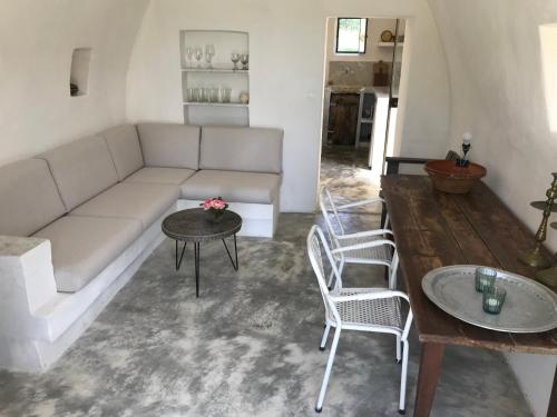 Le cabanon في Vaugines: غرفة معيشة مع أريكة وكرسيين وطاولة
