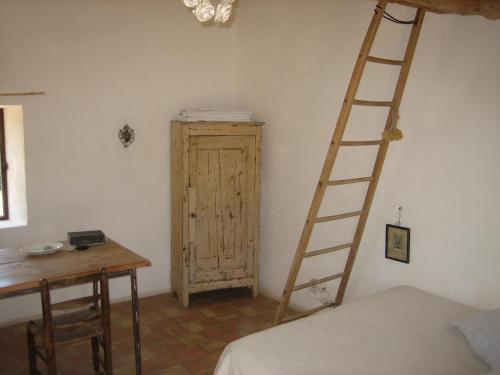 Le cabanon في Vaugines: غرفة بها سلم بجوار سرير ومكتب