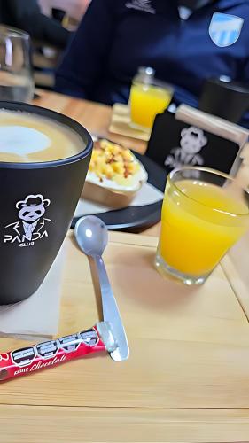 圣米格尔·德·图库玛Moderna Suite GPT con piscina y cochera的桌子上放着一杯咖啡和一杯橙汁