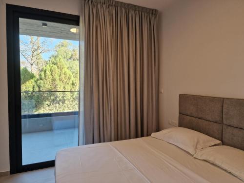 een slaapkamer met een bed en een groot raam bij Hypnos Residence Acropolis in Strovolos