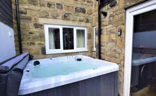 a large bath tub in a room with a window at Coachway Cottage in Ilkley