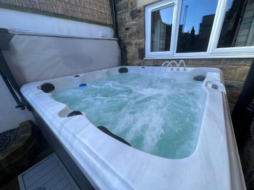 a jacuzzi tub in a room with a window at Coachway Cottage in Ilkley