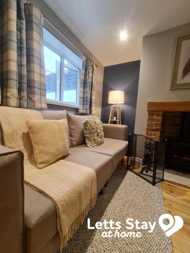 a living room with a couch and a window at Coachway Cottage in Ilkley