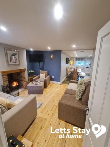 a living room with a couch and a fireplace at Coachway Cottage in Ilkley