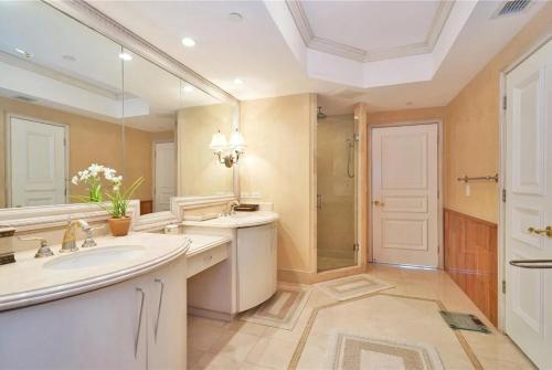 a bathroom with a sink and a large mirror at Ocean & Intercoastal Views in Sunny Isles Beach