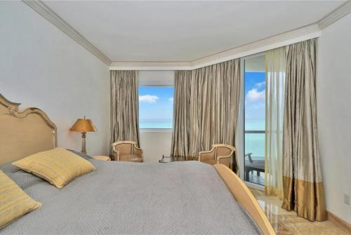 a bedroom with a bed and a large window at Ocean & Intercoastal Views in Sunny Isles Beach