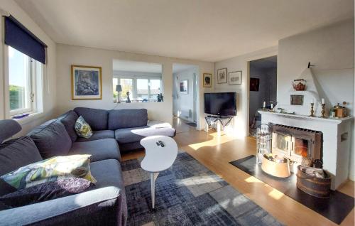 a living room with a couch and a fireplace at 4 Bedroom Beautiful Home In Heberg in Grimsholmen