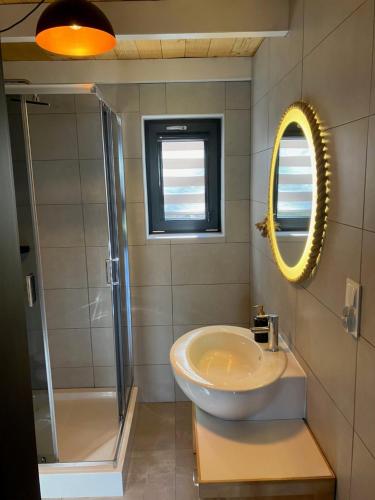 a bathroom with a sink and a shower and a mirror at domkibajka 