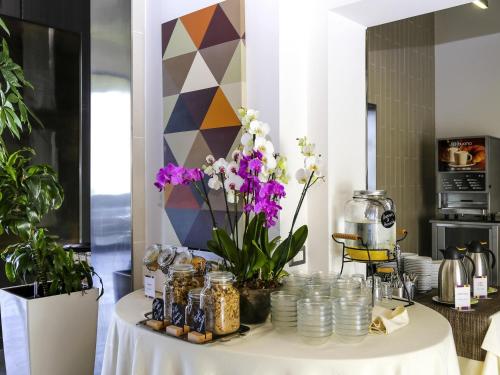 a table with flowers and jars on it at Ibis Styles Roma Eur in Rome