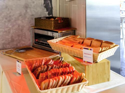 three baskets of hot dogs and bread on a counter at Ibis Styles Roma Eur in Rome