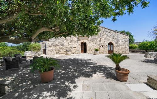 un edificio de piedra con dos macetas delante de él en Pet Friendly Home In Ragusa, en Ragusa