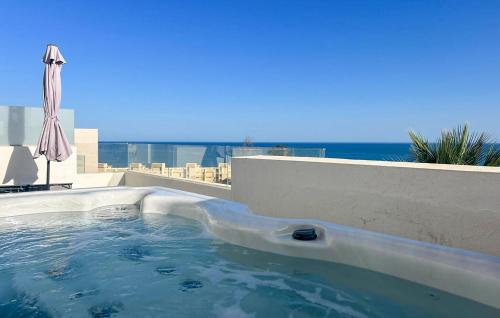a swimming pool with an umbrella and the ocean at 4 Bedroom Gorgeous Home In Fuengirola in Las Lagunas Mijas