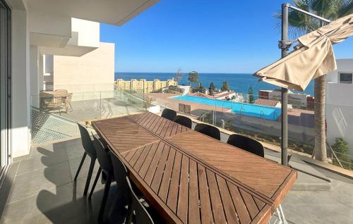 a wooden table on a balcony with a view of the ocean at 4 Bedroom Gorgeous Home In Fuengirola in Las Lagunas Mijas