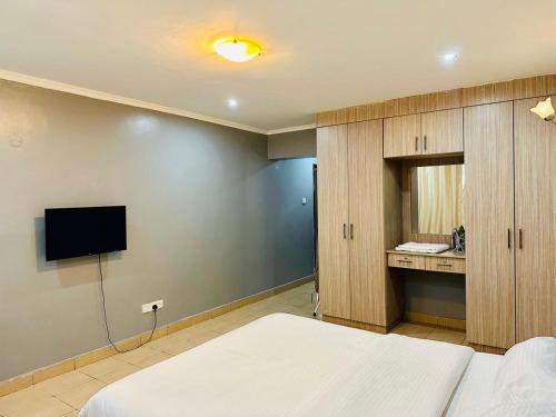 a bedroom with a bed and a flat screen tv at Nersheys 2 bedroom Apartment near Junction Mall in Nairobi