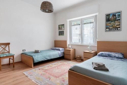 a bedroom with two beds and a window at Appartamento Spormaggiore in Spormaggiore