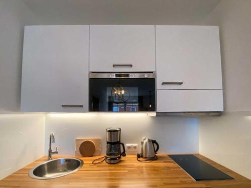 a kitchen with a sink and a stove top oven at Lachmoewe in Orth