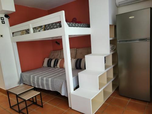 ein Etagenbett in einem Zimmer mit einem Bett und einem Etagenbett in der Unterkunft studio colibri in Saint-François