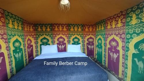 a bedroom with a bed with a colorful wallpaper at Family Berber Camp in Merzouga