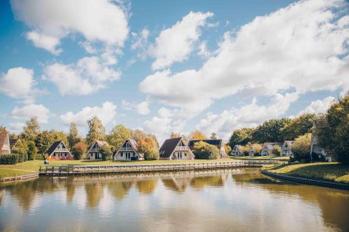 a row of houses next to a river at 't Hooge Holt in Gramsbergen