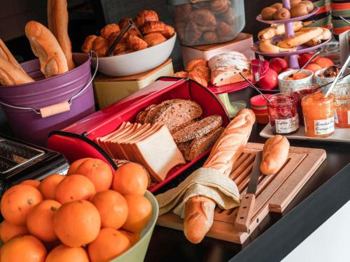 ibis Styles Paris Velizy في فيليزي-فيياكوبليه: طاولة مليئة بالكثير من أنواع الخبز المختلفة