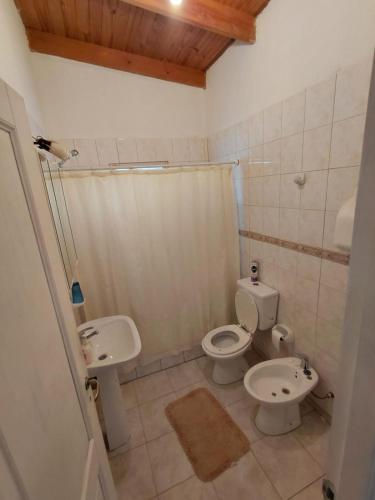 a bathroom with two toilets and a sink and a shower at Refugio del Viento in Gobernador Gregores