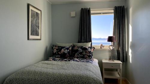 a bedroom with a bed with a view of the ocean at Sjelefred - Ocean Suite in Sortland