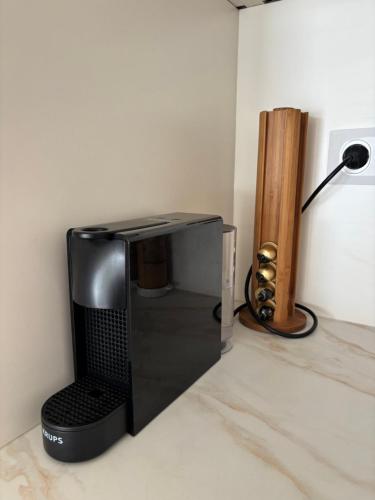 Eine schwarze Mikrowelle steht auf einer Arbeitsplatte neben einer Lampe. in der Unterkunft Appartement T2 chambre plus cabine, terrasse vue piscine in Bormes-les-Mimosas