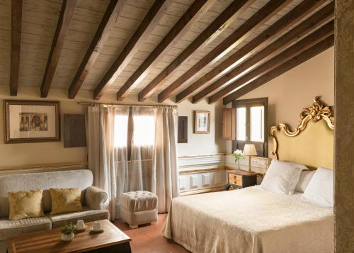 a bedroom with a king sized bed and a couch at Hotel Casa 1800 Granada in Granada