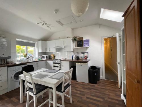 a kitchen with a white table and chairs in it at Golden Triangle Rooms in Norwich