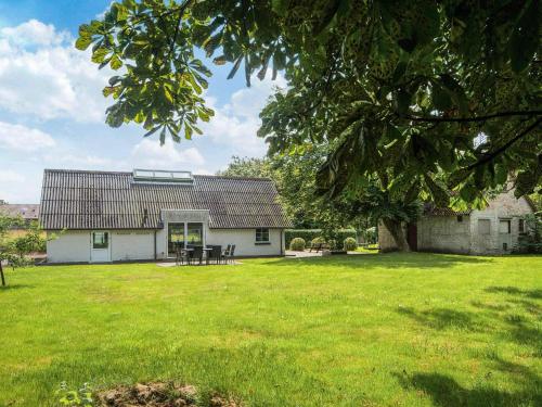 a white house with a picnic table in a yard at 6 person holiday home in Løkken in Løkken