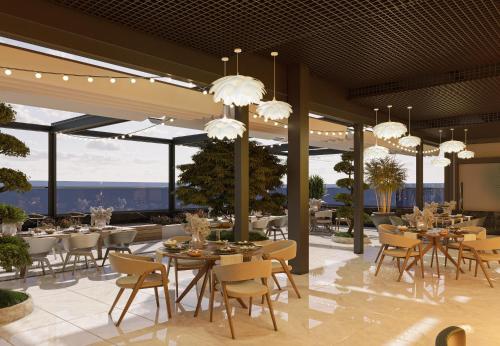 een restaurant met tafels, stoelen en kroonluchters bij Grand Dior in Tasjkent