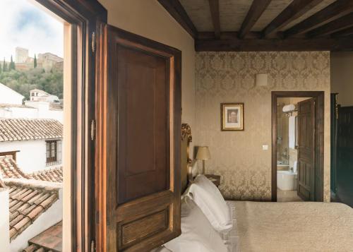 a bedroom with a door leading to a balcony at Hotel Casa 1800 Granada in Granada
