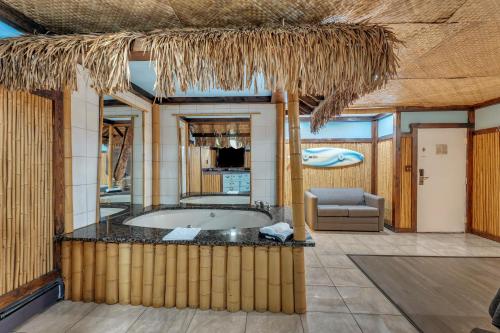 a bathroom with a tub in a resort with a couch at Bentley Motel in Linden